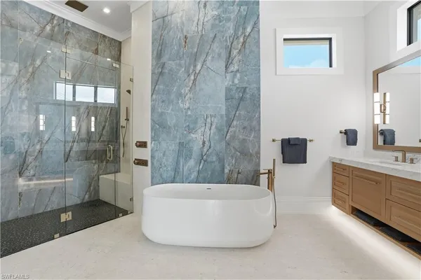 a spacious bathroom with a tub sink and mirror