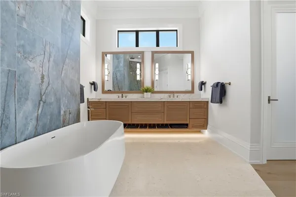 a spacious en suite bathroom with a tub and mirror