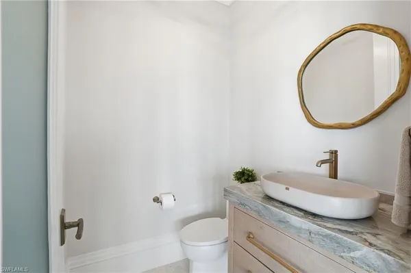 a bathroom with a granite countertop toilet and a sink