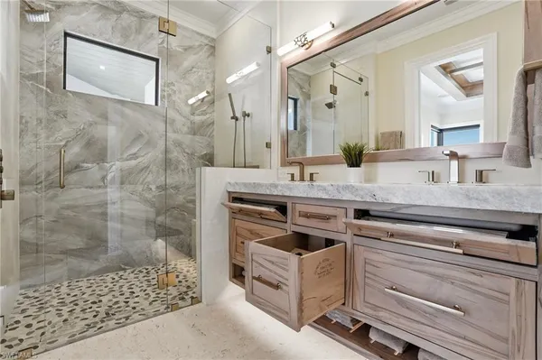a bathroom with a granite countertop sink a mirror a vanity and a shower