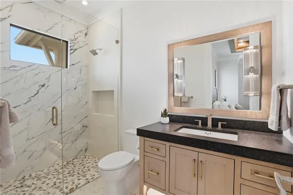 a bathroom with a granite countertop sink toilet and shower