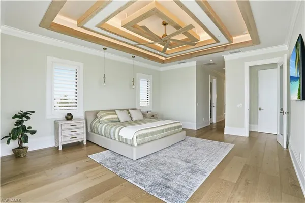 a spacious bedroom with a large bed and a chandelier