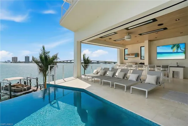 a living room with furniture kitchen view and a large window
