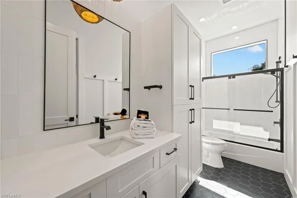 a bathroom with a sink a toilet and a mirror