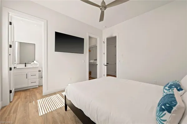 a bedroom with a bed and a flat tv screen on dresser