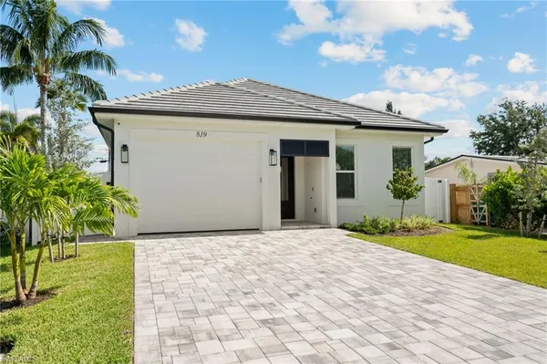 a front view of a house with a garden and yard