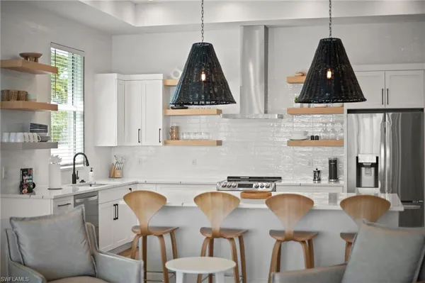 a kitchen with stainless steel appliances a dining table and chairs
