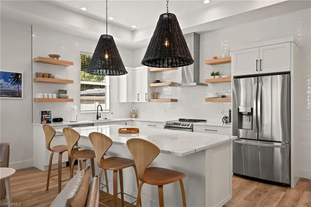 a kitchen with stainless steel appliances a sink a stove a refrigerator and cabinets