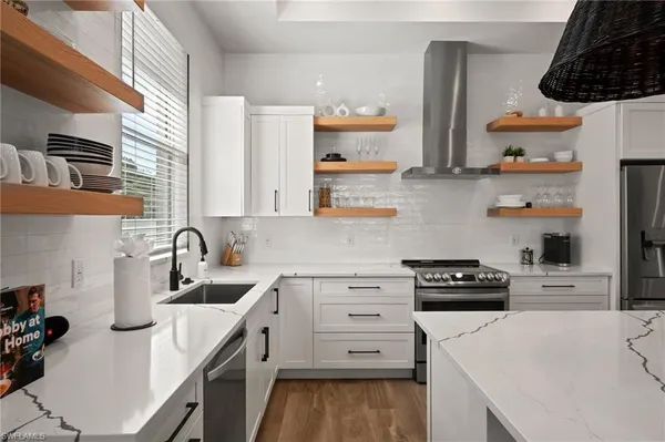 a kitchen with white cabinets and appliances
