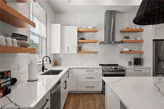 a kitchen with white cabinets and appliances