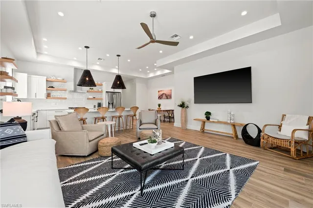 a living room with furniture a flat screen tv and kitchen view