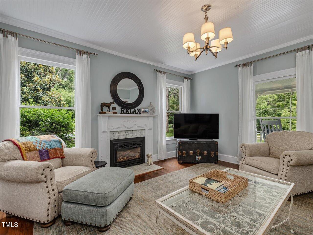 967 Bynum Road Pittsboro, NC 27312 - Photo 22 of 100 a living room with furniture a fireplace and a flat screen tv