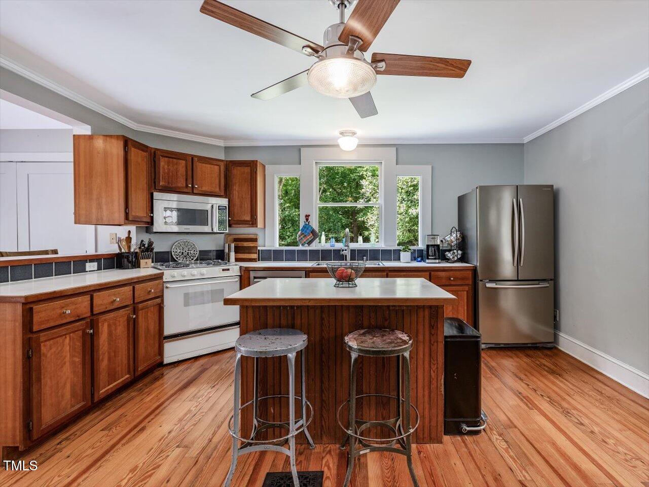 967 Bynum Road Pittsboro, NC 27312 - Photo 31 of 100 a kitchen with stainless steel appliances granite countertop a refrigerator a stove a sink dishwasher a dining table and chairs with wooden floor