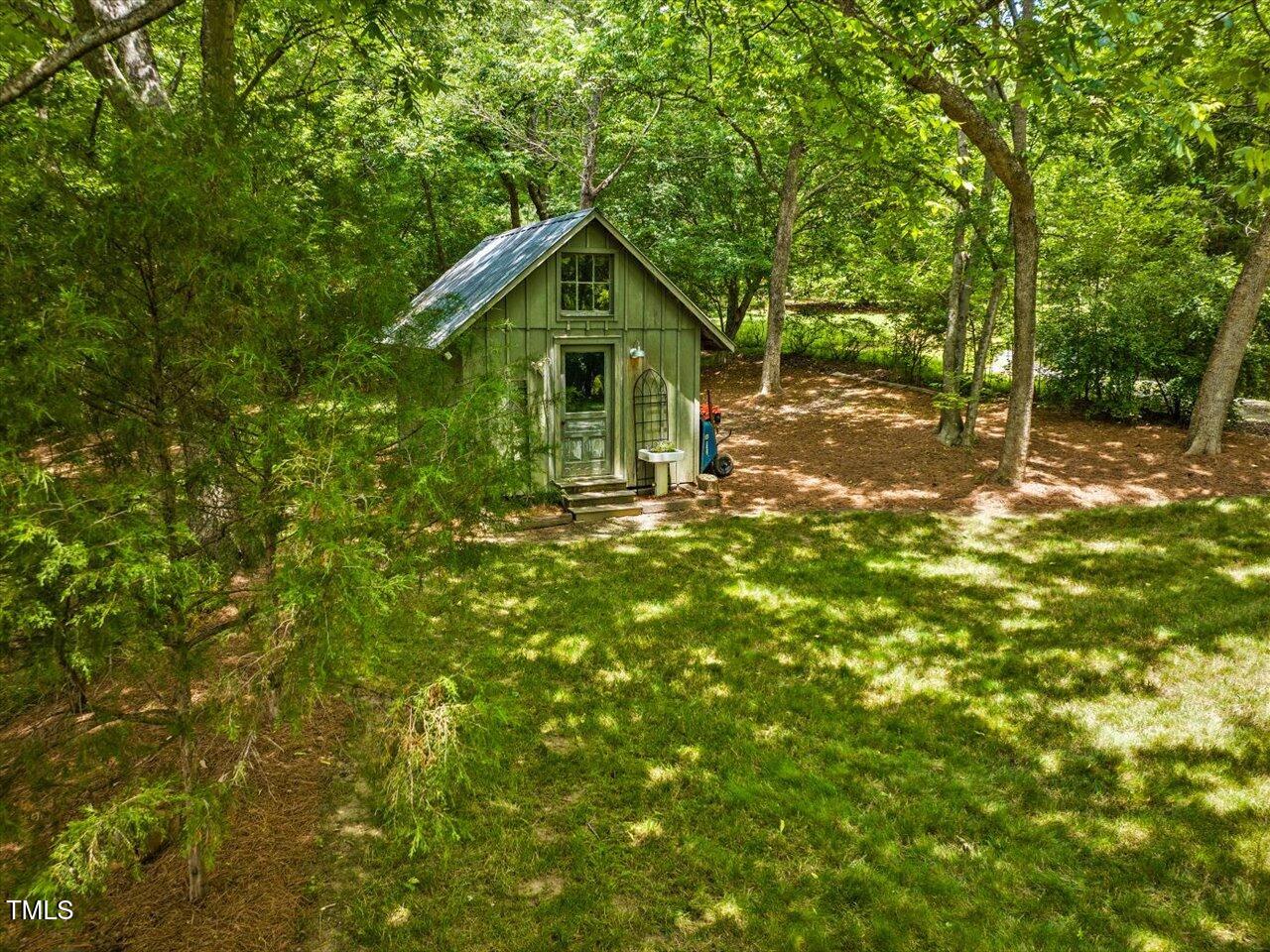 967 Bynum Road Pittsboro, NC 27312 - Photo 91 of 100 a backyard of a house with plants and large trees