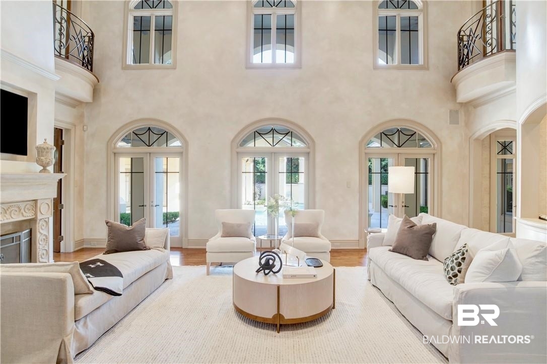 4 Chancery Court Mobile, AL 36608 - Photo 11 of 54 Living room featuring a premium fireplace, wood-type flooring, a towering ceiling, and french doors