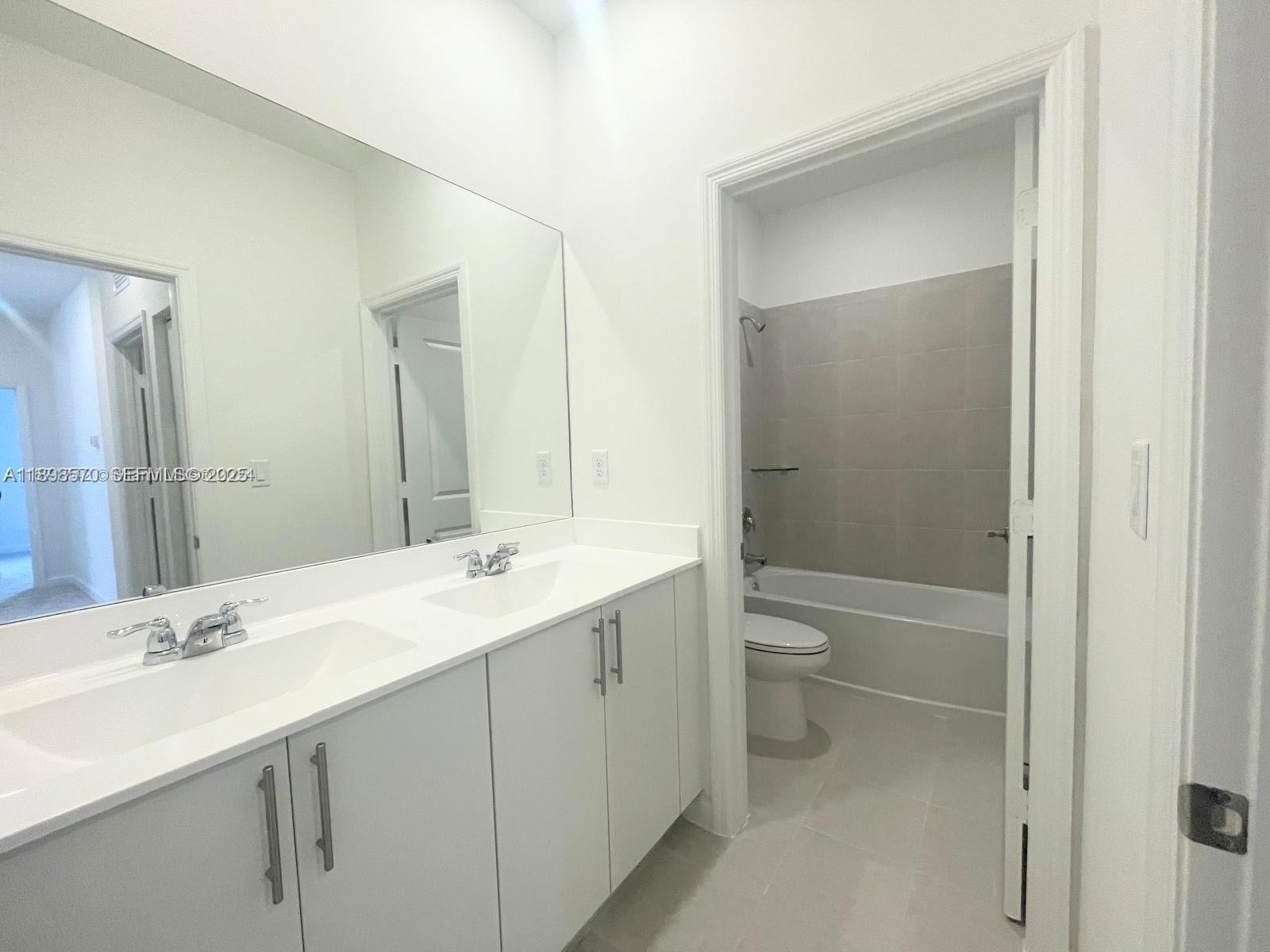 2647 Southeast 8th Street Homestead, FL 33030 - Photo 14 of 25 a bathroom with a double vanity sink toilet and shower