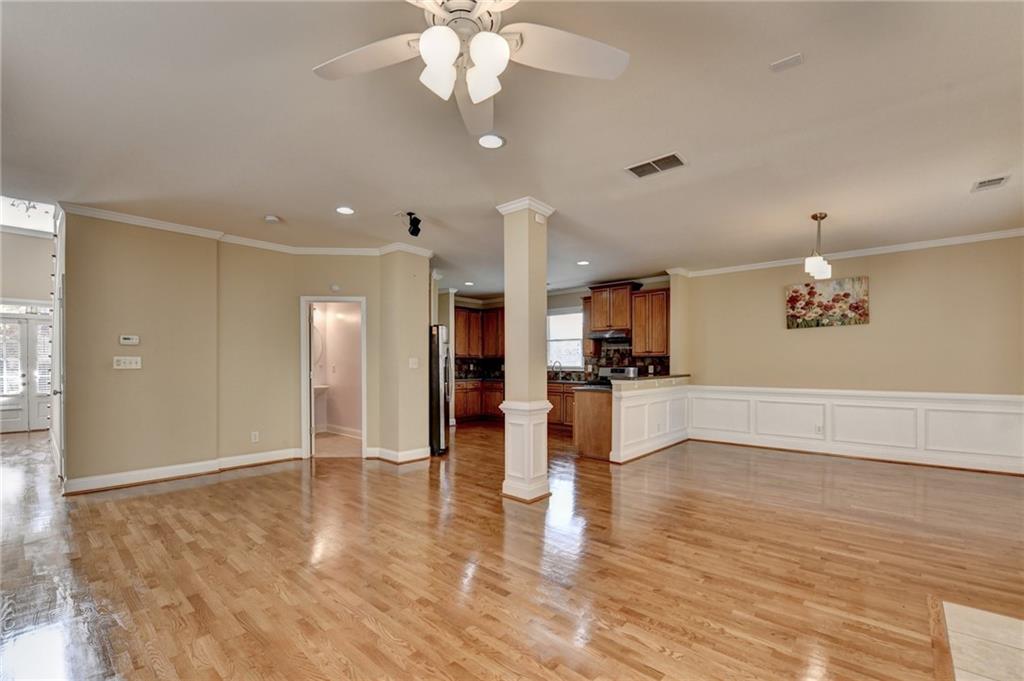 5063 Micaela Way Duluth, GA 30096 - Photo 15 of 61 a view of an empty room and kitchen with wooden floor