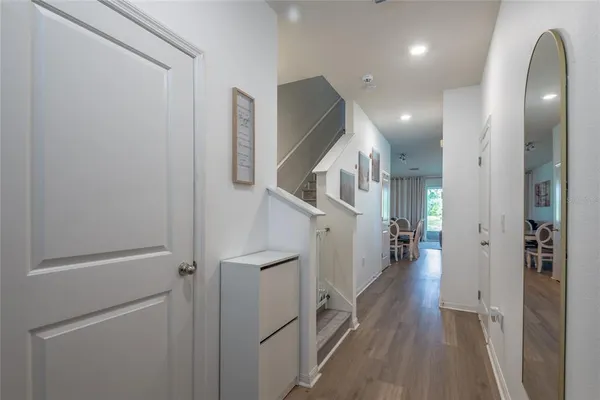 a view of hallway with stairs and wooden floor