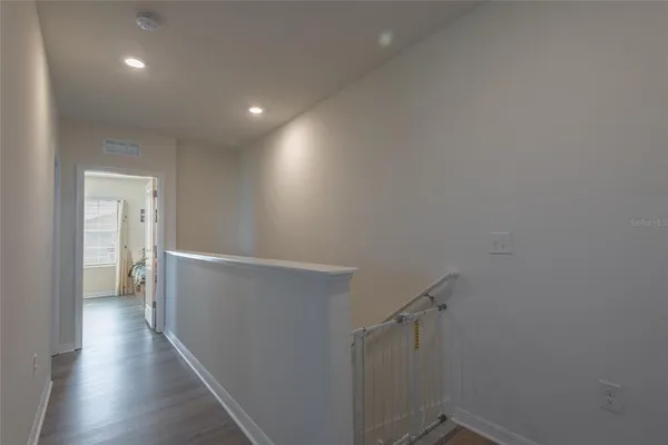 a view of a hallway with wooden floor