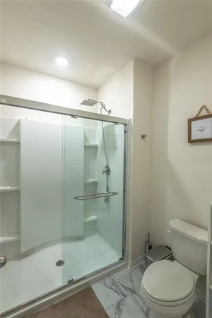a bathroom with a shower a toilet and a sink