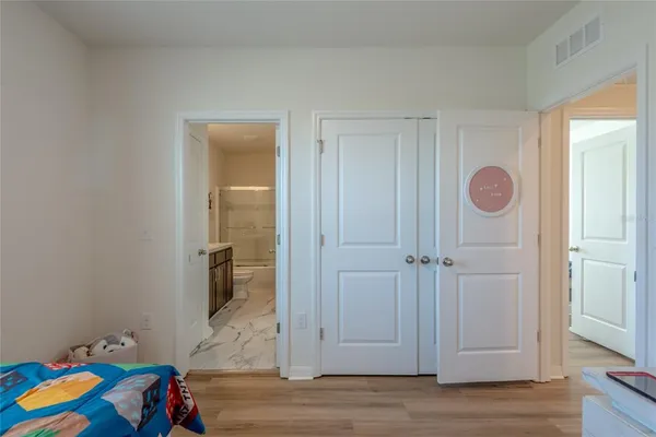 a bedroom with bed and wooden floor