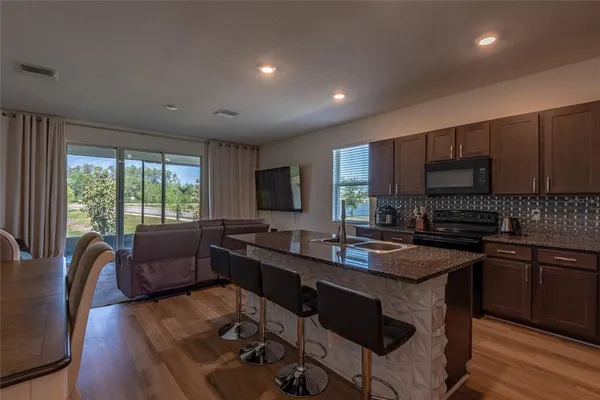 a kitchen with granite countertop appliances a sink and cabinets