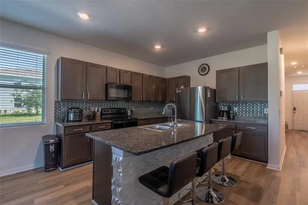 a kitchen with stainless steel appliances granite countertop a sink stove and refrigerator