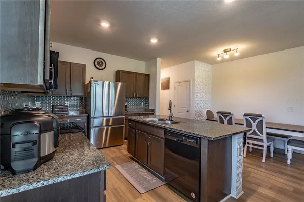 a kitchen with stainless steel appliances granite countertop a sink stove and refrigerator