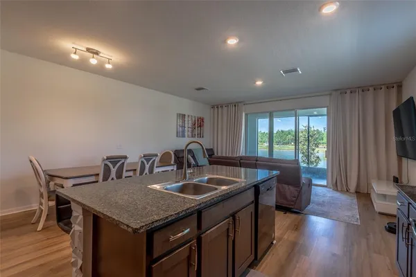 a kitchen with a table chairs and wooden floor