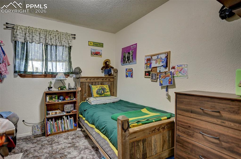 9420 Mulberry Road Calhan, CO 80808 - Photo 18 of 49 a bedroom with a bed and wooden floor