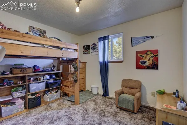 a view of a bedroom with clothes shoes and a workspace