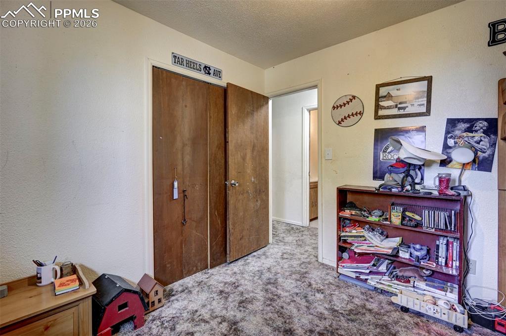 9420 Mulberry Road Calhan, CO 80808 - Photo 21 of 49 a view of a bedroom with clothes shoes and a workspace