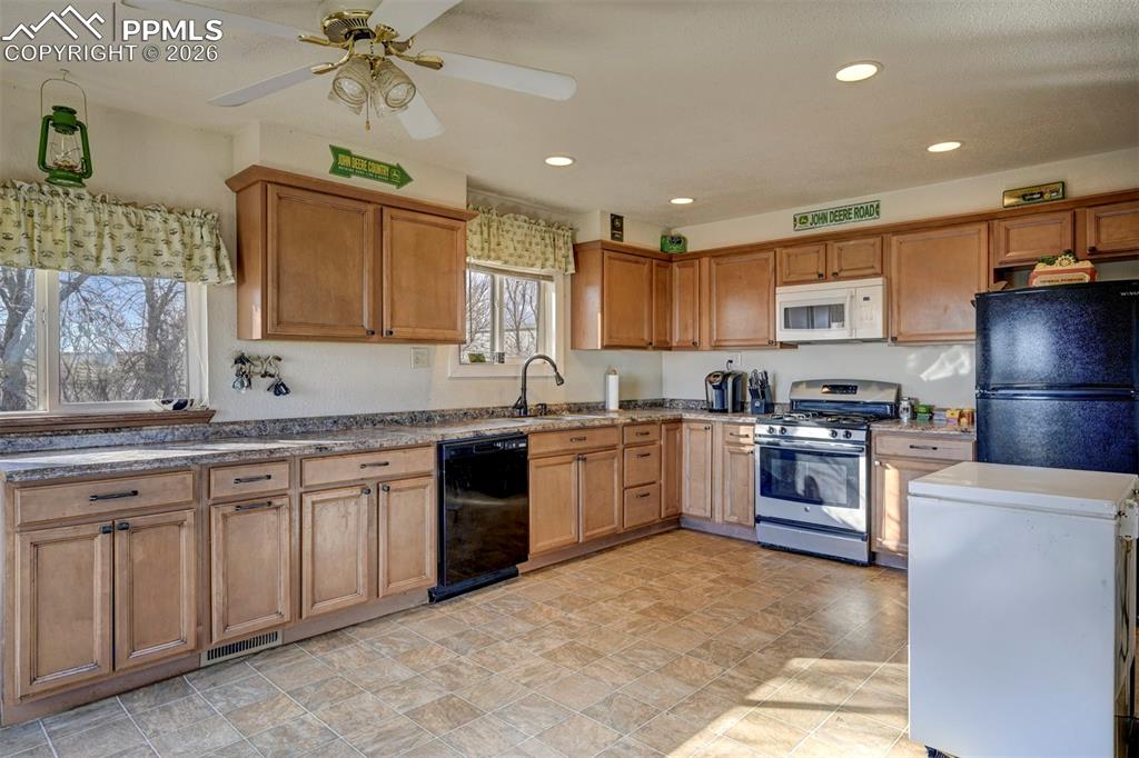 9420 Mulberry Road Calhan, CO 80808 - Photo 4 of 49 a kitchen with stainless steel appliances granite countertop a stove sink and cabinets