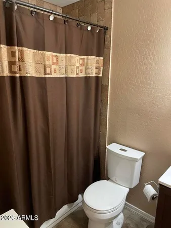 a bathroom with a toilet and a shower curtain