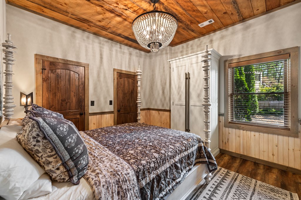 239 Covered Bridge Lane Cherry Log, GA 30522 - Photo 36 of 50 a bedroom with a large bed and a chandelier