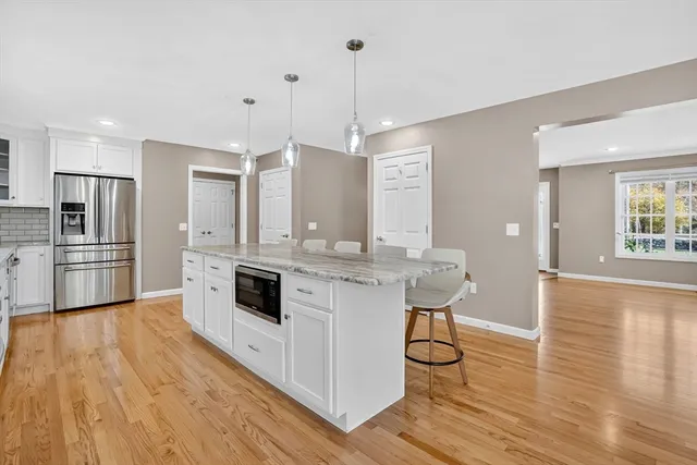 a kitchen with stainless steel appliances a kitchen island hardwood floor sink and stove