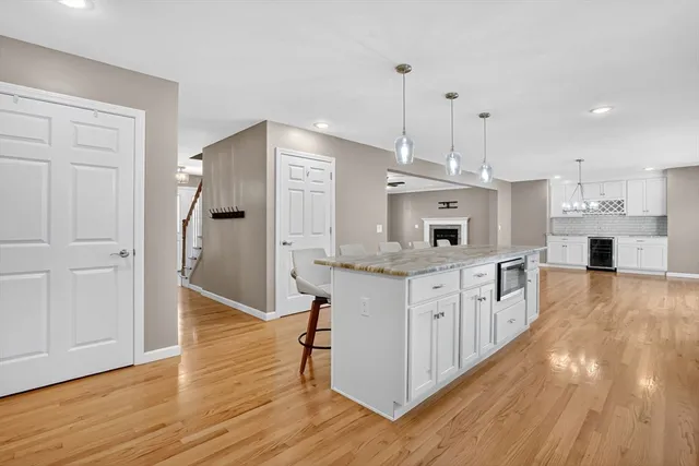 a kitchen with stainless steel appliances granite countertop a white refrigerator a stove a sink and a wooden floors