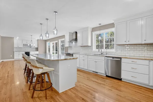 a kitchen with stainless steel appliances granite countertop a white cabinets and wooden floor