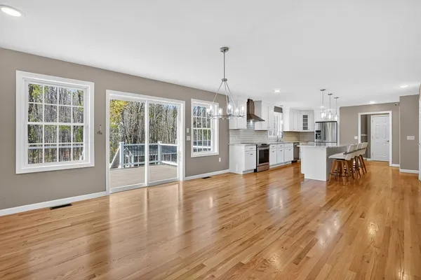 a view of a living room and kitchen with furniture wooden floor and windows