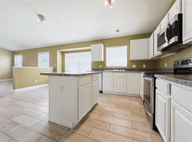 a large kitchen with cabinets and stainless steel appliances