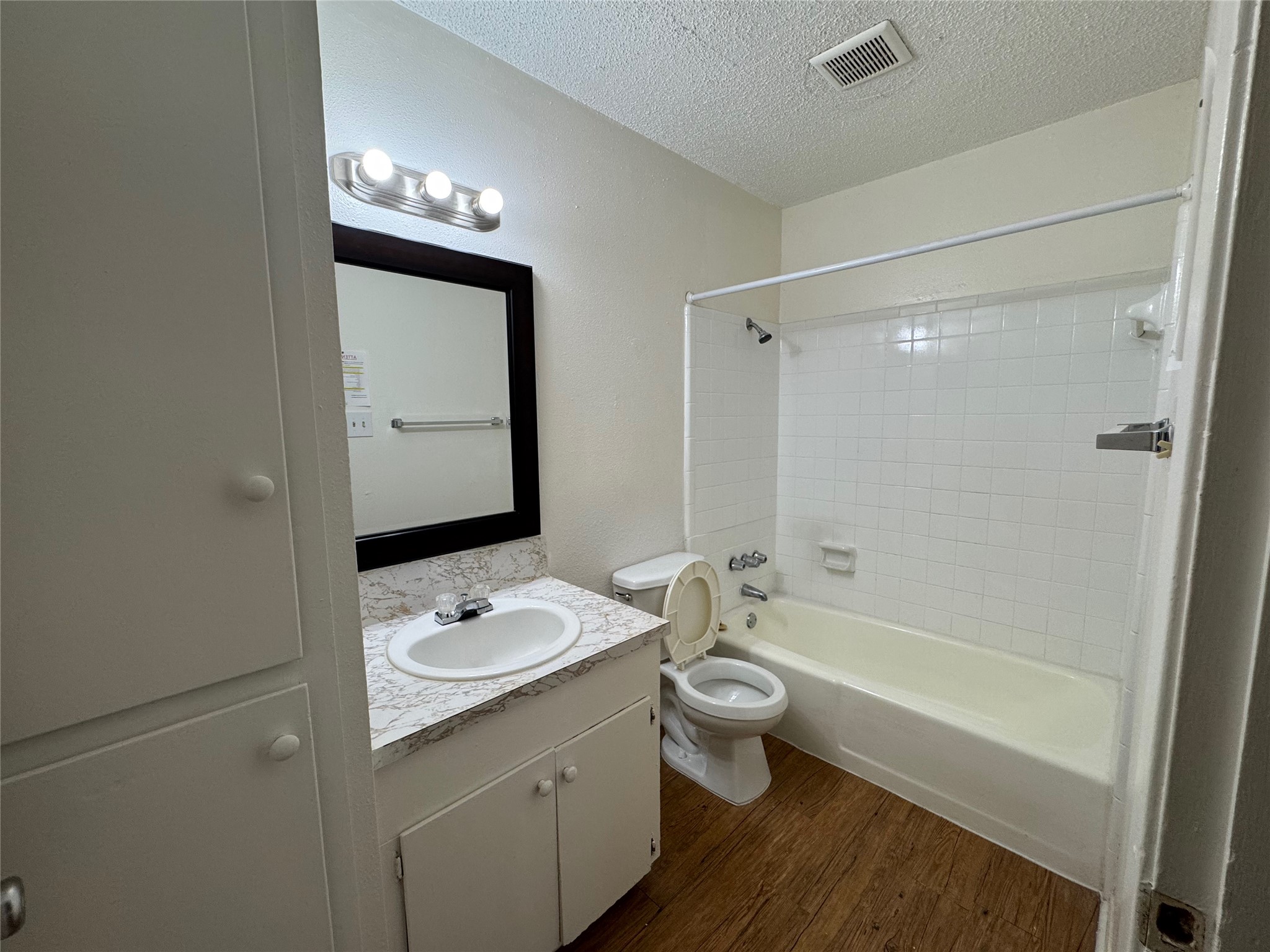 4902 West Wind Trail, Unit 103 Austin, TX 78745 - Photo 12 of 20 a bathroom with a double vanity sink a toilet a shower and a mirror