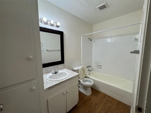 a bathroom with a double vanity sink a toilet a shower and a mirror