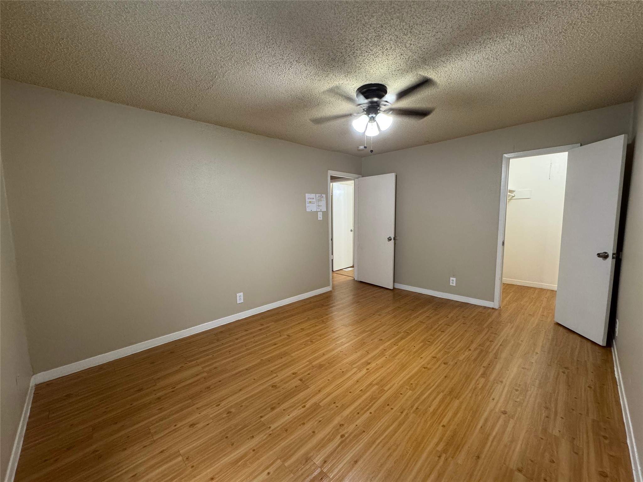 4902 West Wind Trail, Unit 103 Austin, TX 78745 - Photo 15 of 20 a view of an empty room with wooden floor and a ceiling fan
