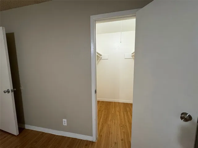 an empty room with wooden floor and closet