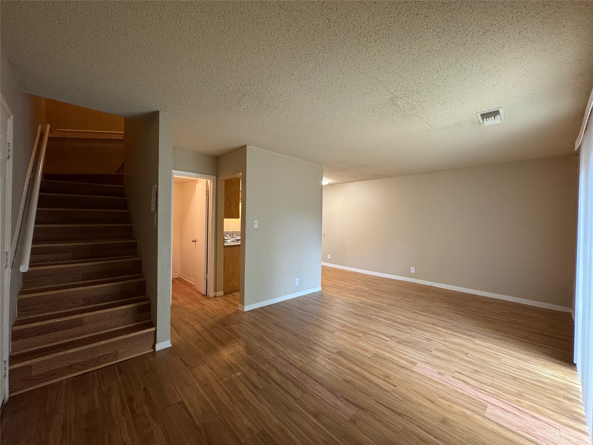 4902 West Wind Trail, Unit 103 Austin, TX 78745 - Photo 3 of 20 a view of an empty room with wooden floor and stairs