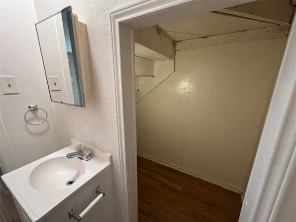 a bathroom with a sink and mirror with bathtub