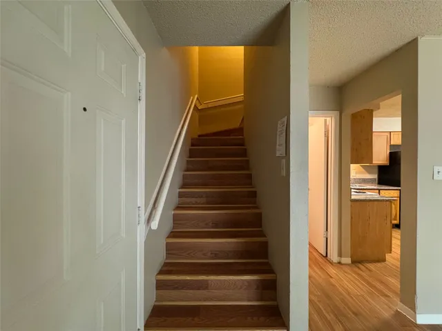 a view of a hallway with wooden floor and entryway