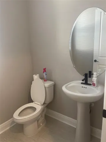 a bathroom with a toilet sink and mirror