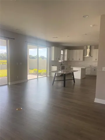 a view of a dining room with furniture a chandelier and wooden floor