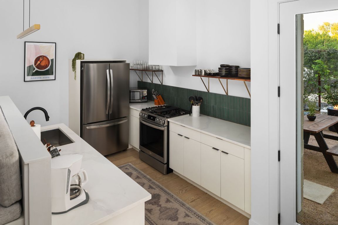 1206 Luna Street Austin, TX 78721 - Photo 14 of 27 a kitchen with a refrigerator and a stove top oven